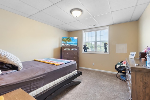 carpeted bedroom with a paneled ceiling, baseboards, and visible vents