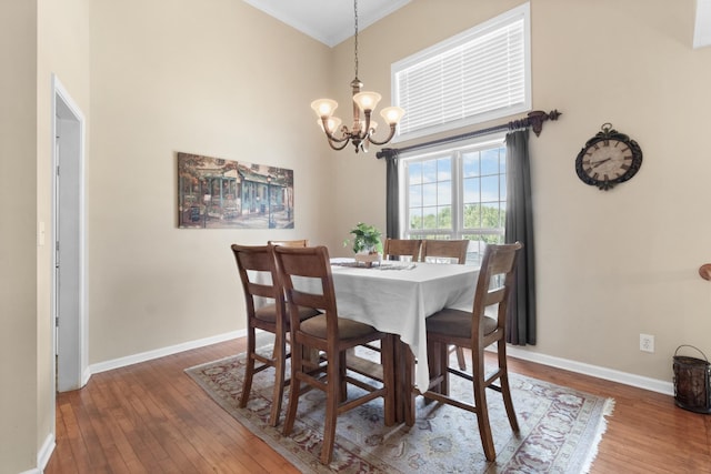 dining space with a notable chandelier, baseboards, and hardwood / wood-style floors