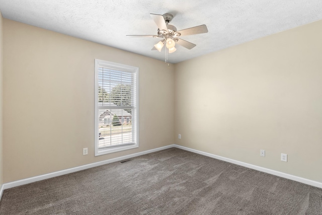 spare room with baseboards, carpet flooring, visible vents, and a textured ceiling