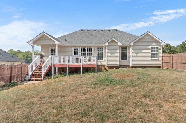 rear view of property with roof with shingles, a lawn, a fenced backyard, and a wooden deck