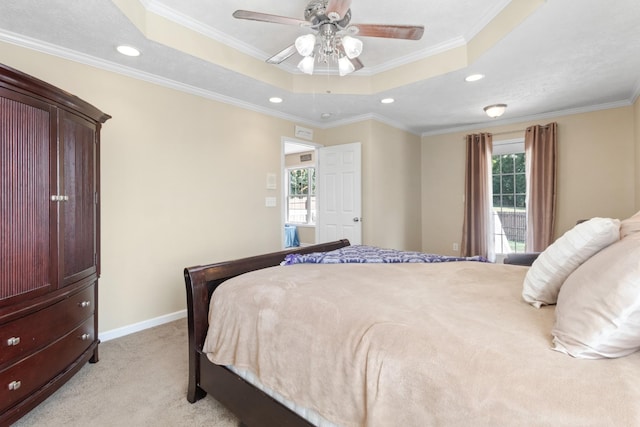 bedroom featuring crown molding, a tray ceiling, and light colored carpet