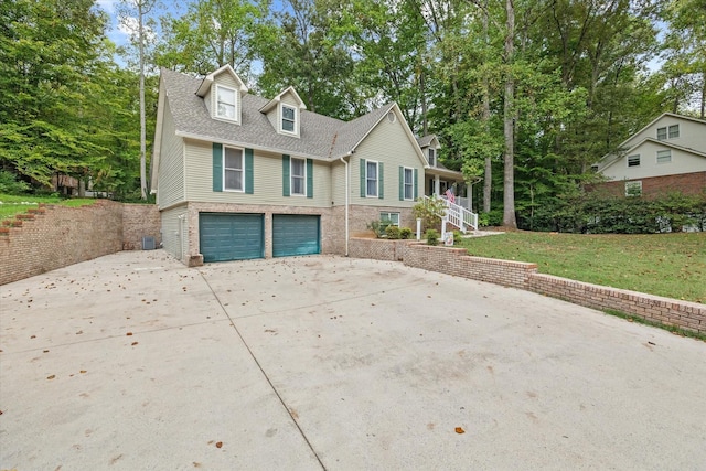 view of front of house with a garage, concrete driveway, roof with shingles, a front yard, and brick siding