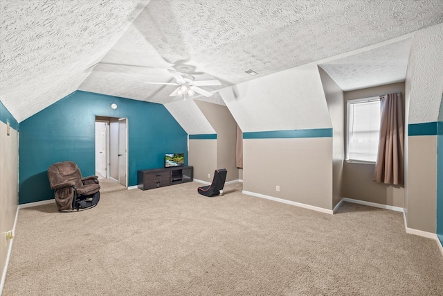 additional living space featuring lofted ceiling, ceiling fan, a textured ceiling, carpet flooring, and baseboards