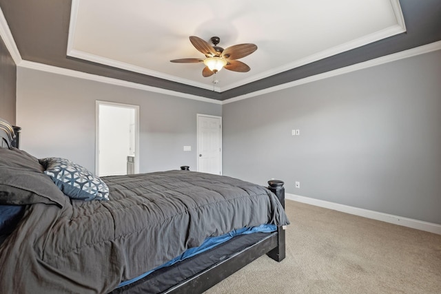 carpeted bedroom with baseboards, a raised ceiling, and crown molding