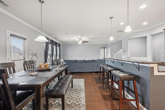 dining space featuring dark wood-style floors, ornamental molding, and visible vents