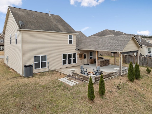 back of property with a patio, an outdoor kitchen, central AC unit, an outdoor fire pit, and fence