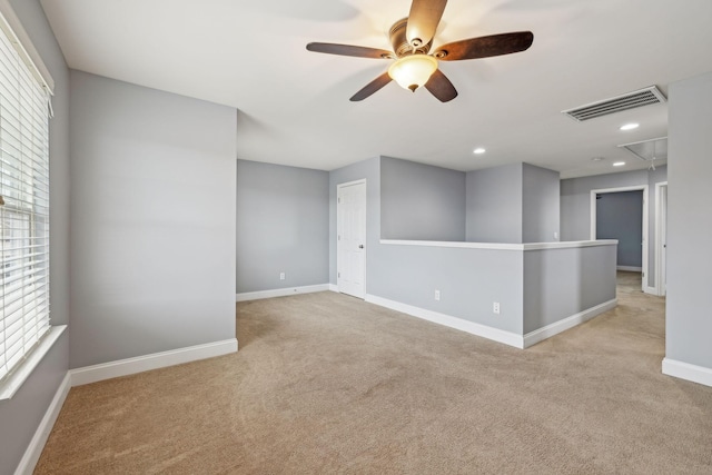 carpeted spare room featuring recessed lighting, visible vents, attic access, ceiling fan, and baseboards