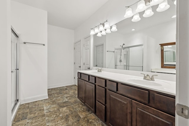 bathroom featuring baseboards, double vanity, a sink, and a shower stall