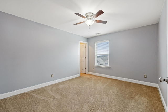 unfurnished room featuring light carpet, visible vents, a ceiling fan, and baseboards