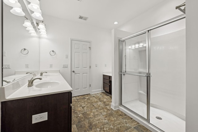 full bathroom with double vanity, a stall shower, a sink, and visible vents