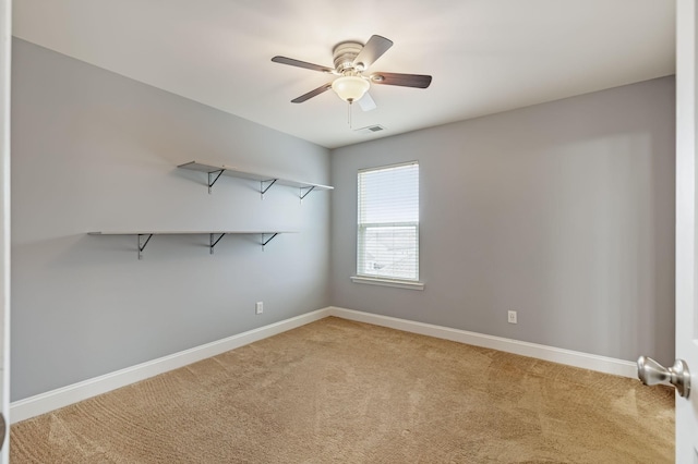 spare room featuring a ceiling fan, visible vents, light carpet, and baseboards