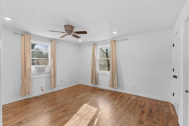 empty room with baseboards, wood finished floors, visible vents, and recessed lighting