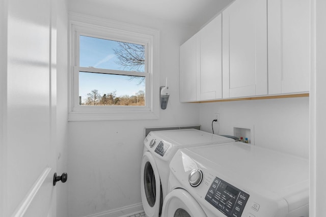 clothes washing area with cabinet space, washing machine and dryer, and baseboards