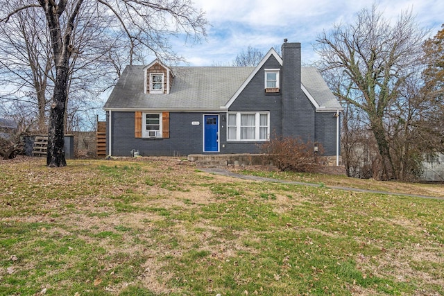 view of front of house featuring brick siding, a chimney, and a front lawn