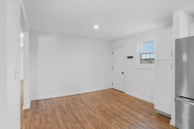 unfurnished room with wood finished floors and baseboards