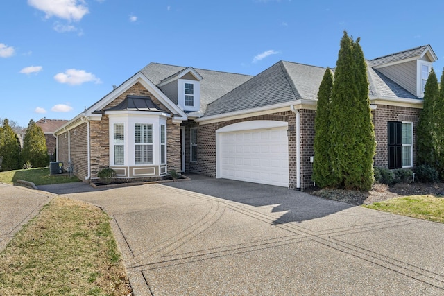 view of front of house with a garage, concrete driveway, a shingled roof, and central air condition unit