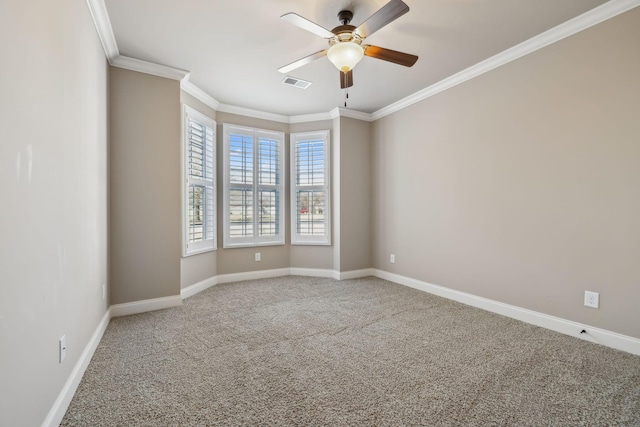 carpeted empty room featuring ornamental molding, a ceiling fan, visible vents, and baseboards