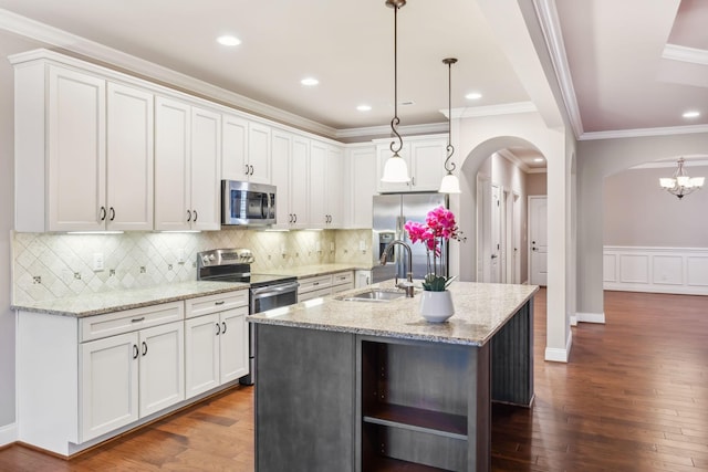 kitchen featuring arched walkways, stainless steel appliances, dark wood-type flooring, and a sink