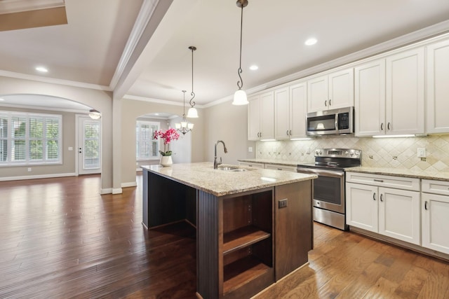 kitchen with arched walkways, stainless steel appliances, dark wood-style flooring, a sink, and open shelves