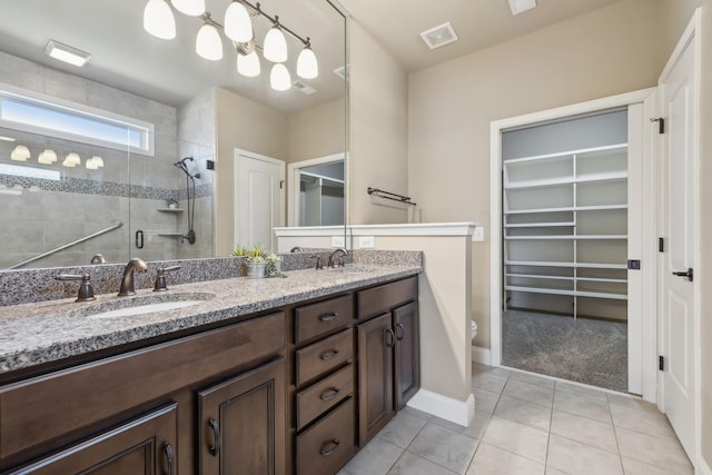 full bathroom featuring a stall shower, visible vents, a sink, and tile patterned floors