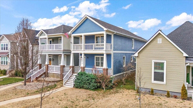 view of front of property with stairway, covered porch, and a balcony