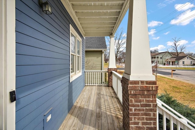 deck featuring covered porch and a residential view