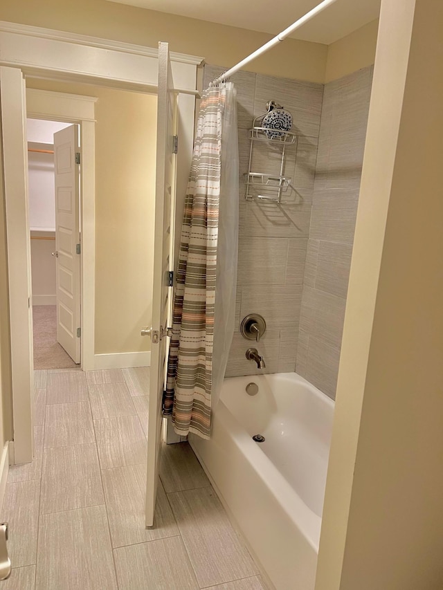 bathroom with shower / tub combo with curtain and baseboards