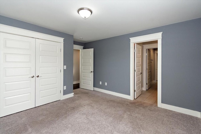 unfurnished bedroom featuring a closet, baseboards, and carpet flooring