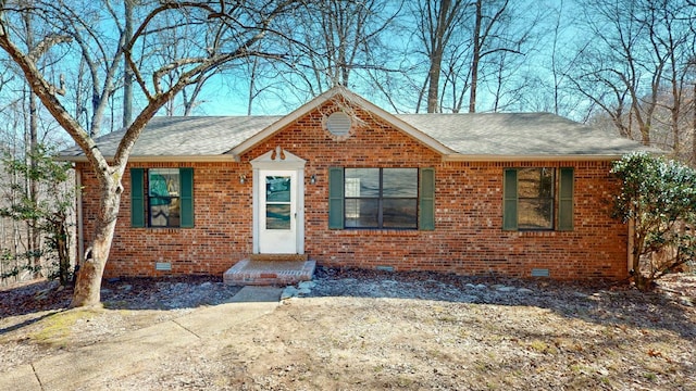 view of front of home featuring brick siding, crawl space, and a shingled roof