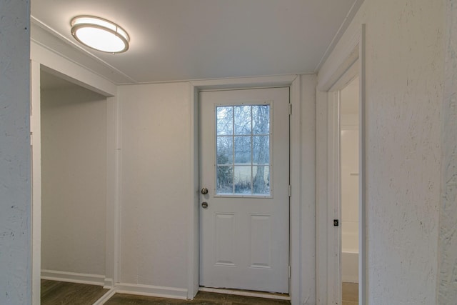 doorway to outside featuring dark wood-style flooring and baseboards