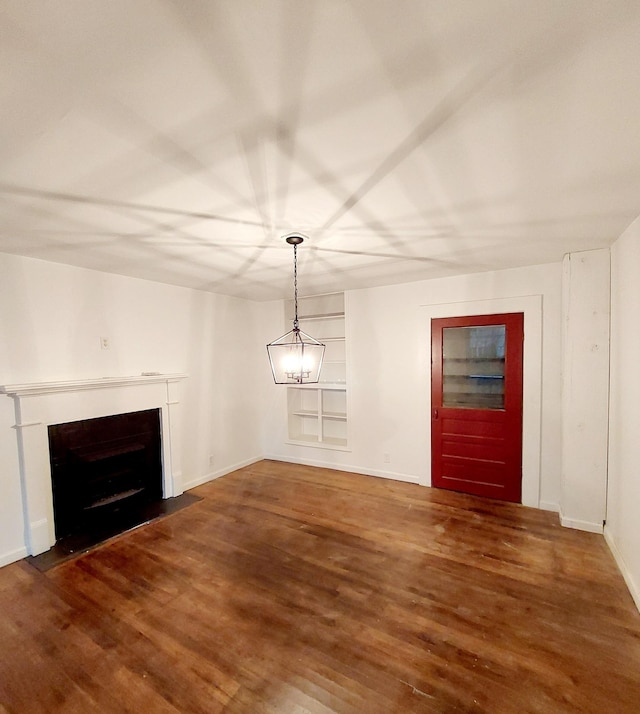 unfurnished living room featuring wood finished floors, a fireplace with flush hearth, and baseboards