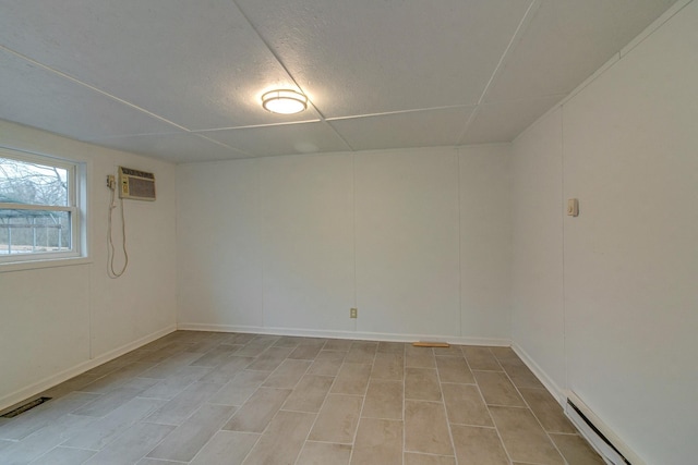 spare room with a baseboard radiator, a wall unit AC, and visible vents