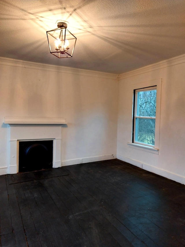 unfurnished living room with dark wood-style flooring, a textured ceiling, crown molding, a fireplace, and a notable chandelier