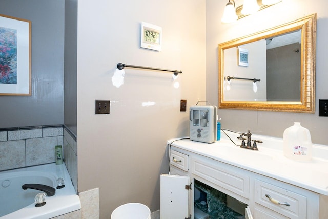 full bath featuring toilet, a garden tub, and vanity