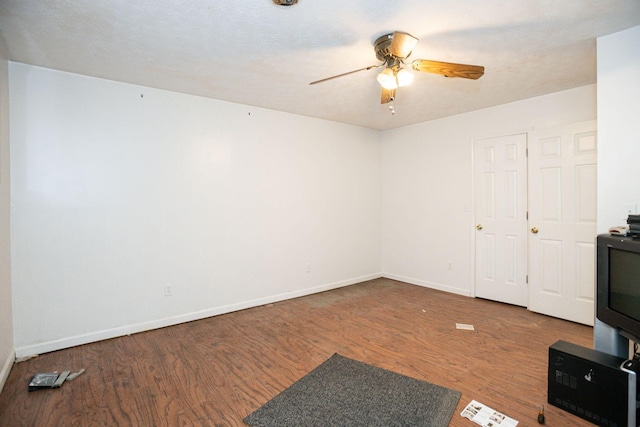 unfurnished room featuring ceiling fan, wood finished floors, and baseboards