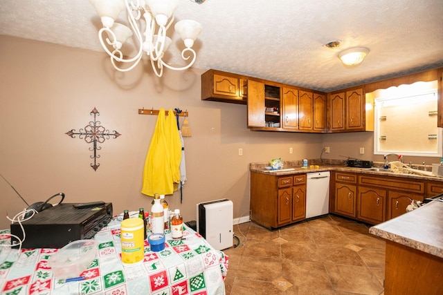 kitchen featuring a textured ceiling, white dishwasher, brown cabinetry, and a sink