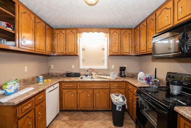 kitchen featuring black appliances, a sink, and brown cabinets