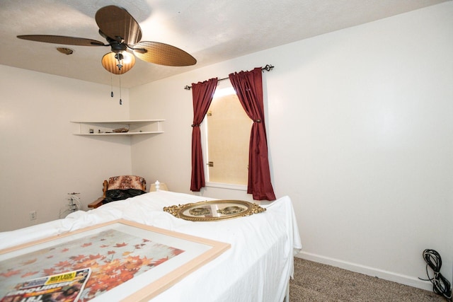 carpeted bedroom with a textured ceiling, baseboards, and a ceiling fan