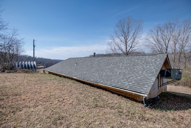 exterior space featuring roof with shingles