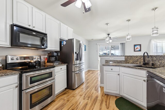 kitchen featuring appliances with stainless steel finishes, white cabinets, and a sink