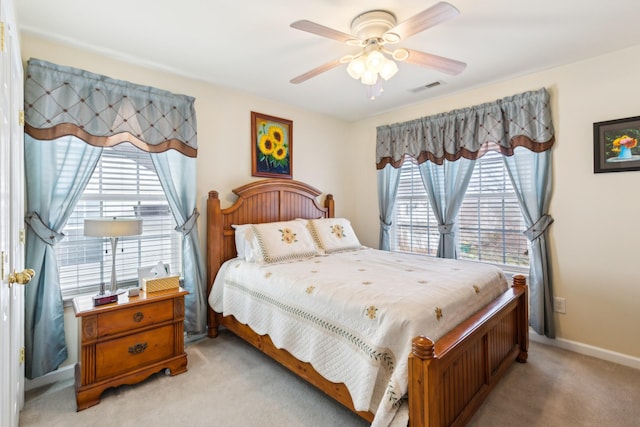 bedroom with light colored carpet, visible vents, ceiling fan, and baseboards