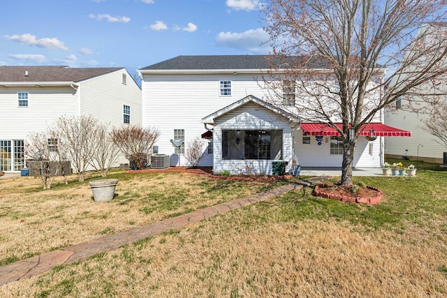 rear view of property with a yard, central AC unit, and a patio