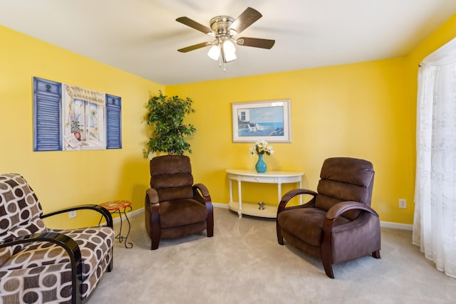 sitting room featuring ceiling fan, carpet flooring, and baseboards