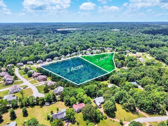 drone / aerial view featuring a wooded view