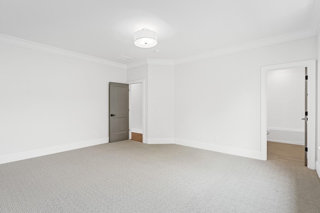 spare room featuring carpet floors, baseboards, and ornamental molding