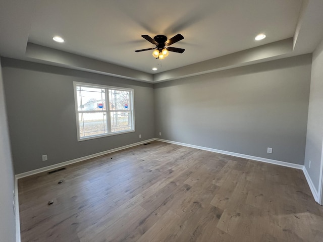 unfurnished room with recessed lighting, visible vents, a ceiling fan, wood finished floors, and baseboards