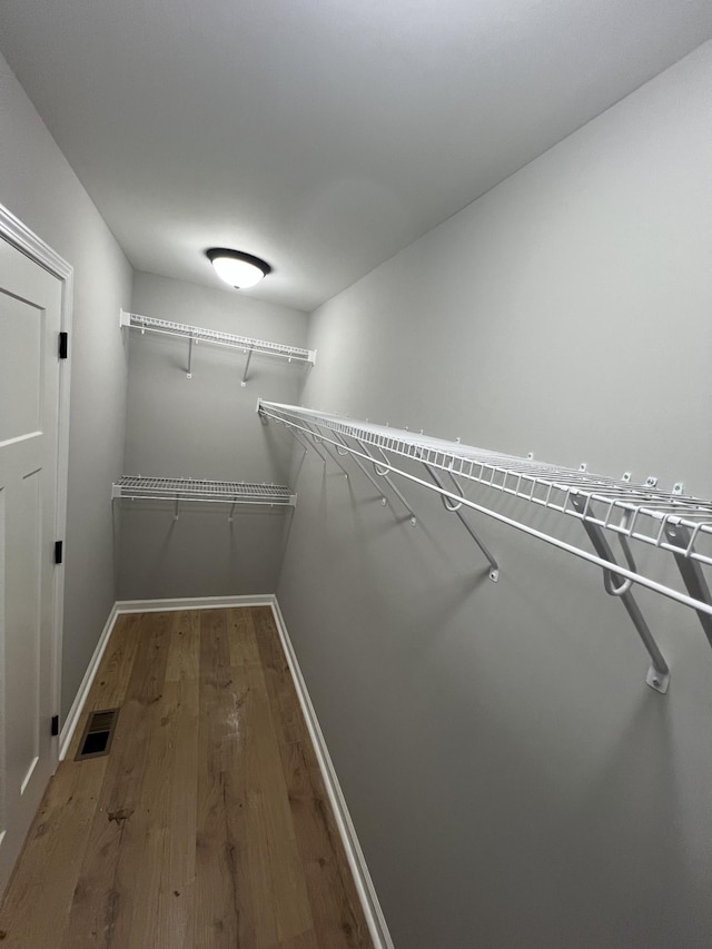 spacious closet featuring wood finished floors and visible vents