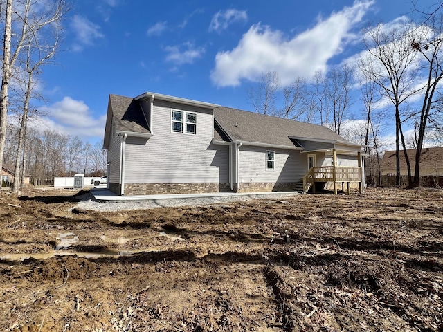 back of house with roof with shingles