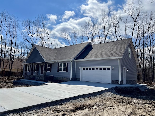 view of front of house with a garage, driveway, and a shingled roof