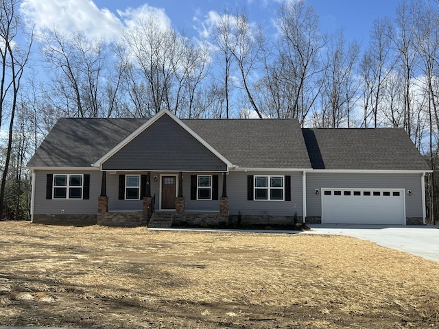craftsman-style home with a shingled roof, a garage, and concrete driveway